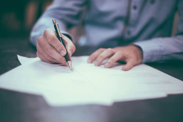 Man writing on sheets of paper