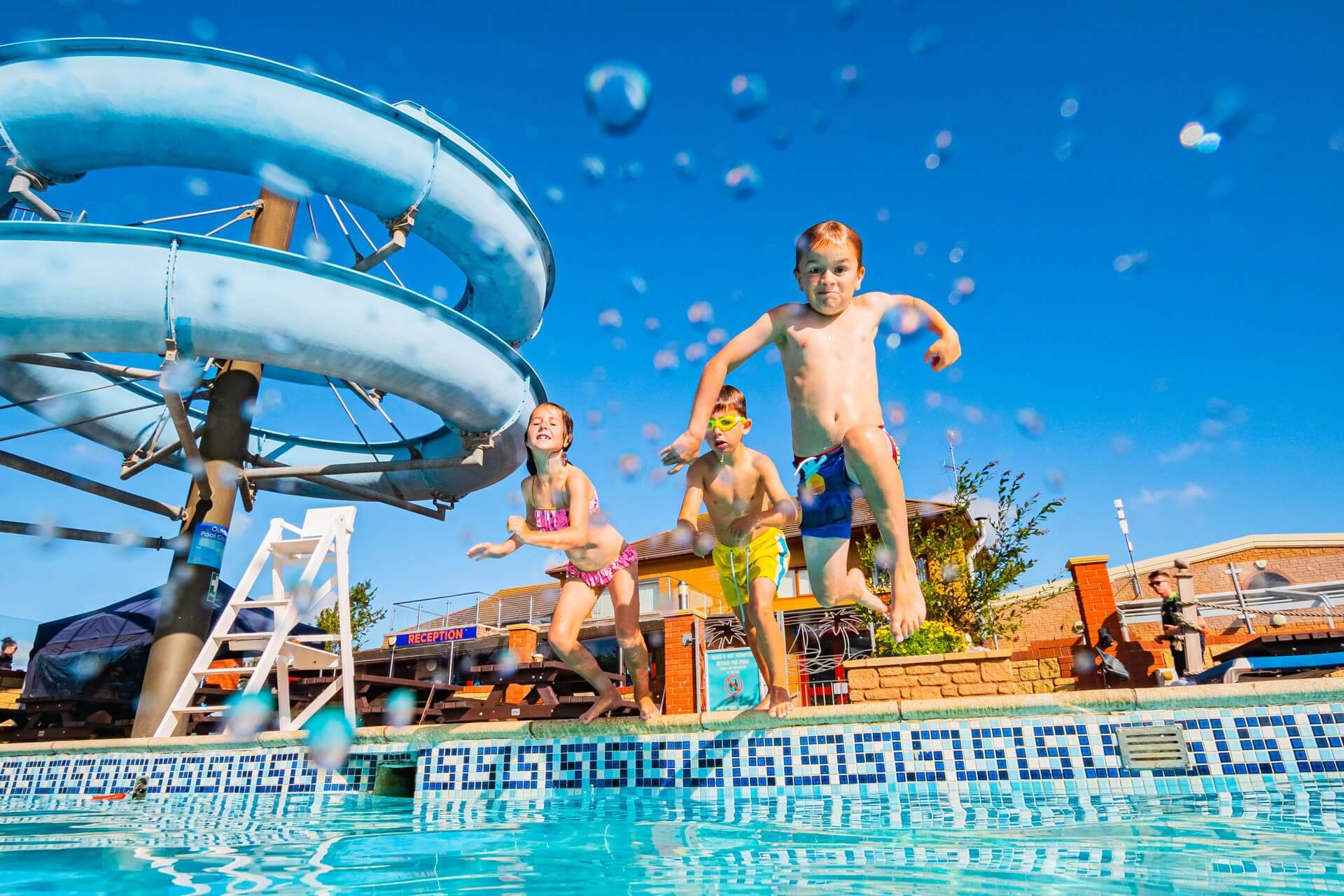 children jumping in outdoor pool