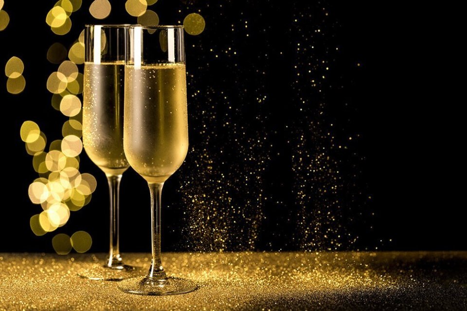Two glasses of champagne surrounded by gold glitter