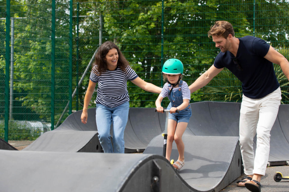 Parents holding their child on a pump track