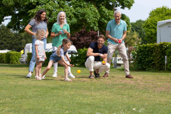 A happy family playing boules on their Whitsun Week escape