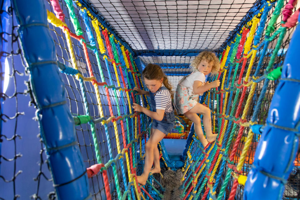 Two young girls in a soft play area