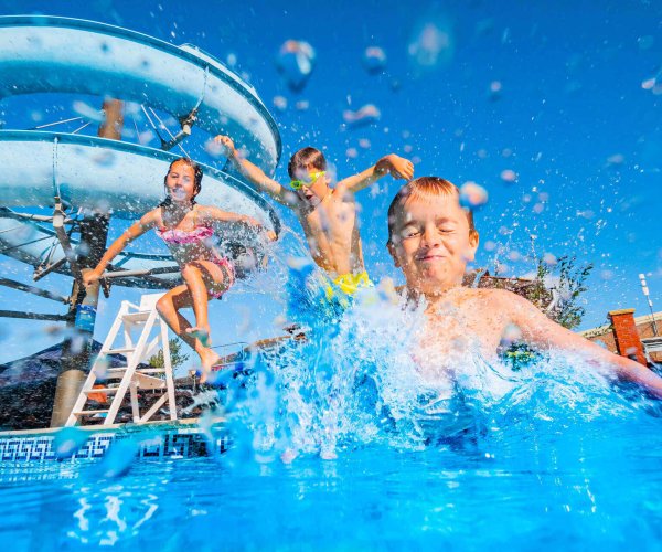 Kids jumping into the Lady's Mile outdoor pool, making a splash