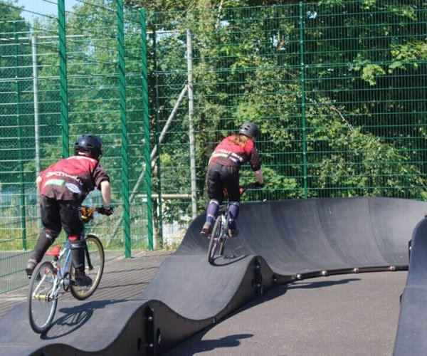 Two kids on bikes on the Bike Pump Track