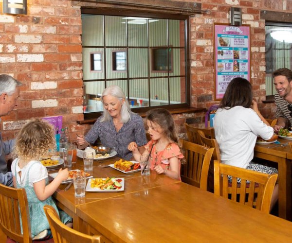 Two groups of people eating dinner at Lady's Mile Oceans Bar & Restaurant