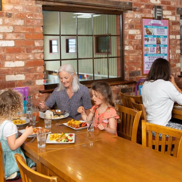 Two groups of people eating dinner at Lady's Mile Oceans Bar & Restaurant